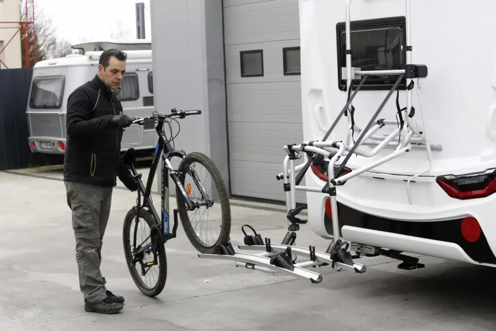 porte vélo camping car vendeur qui tient un vélo à côté d'un camping-car