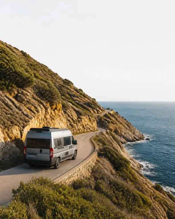 Corse camping car location : van aménagé sur une route étroite du Cap Corse avec vue sur la mer